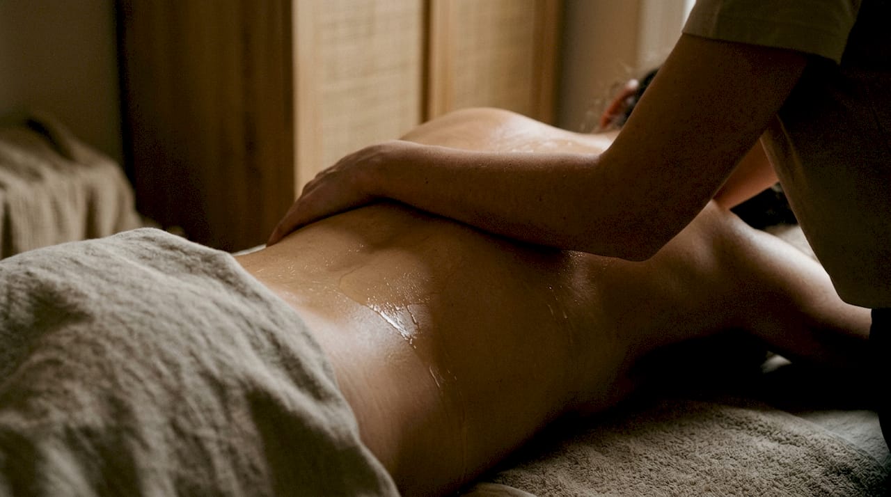 Gros plan sur un contact chaleureux d’huile de massage corps à corps