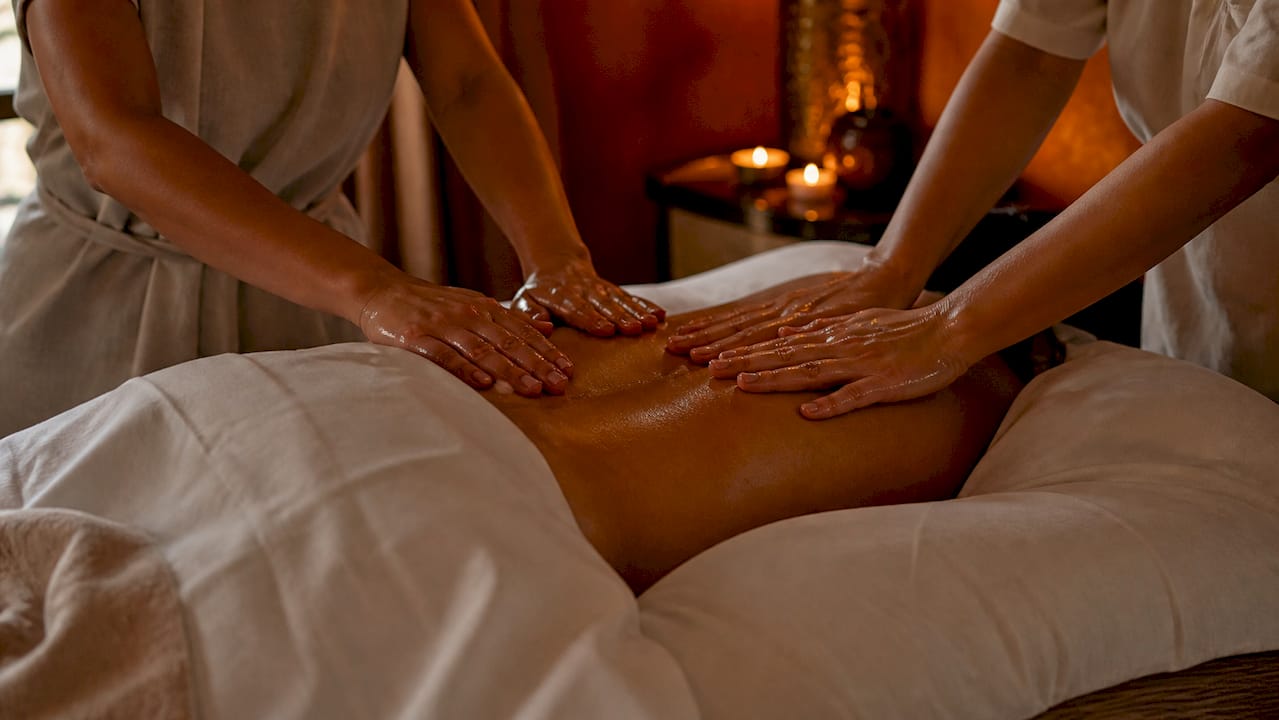 Deux paires de mains réalisant un massage à quatre mains