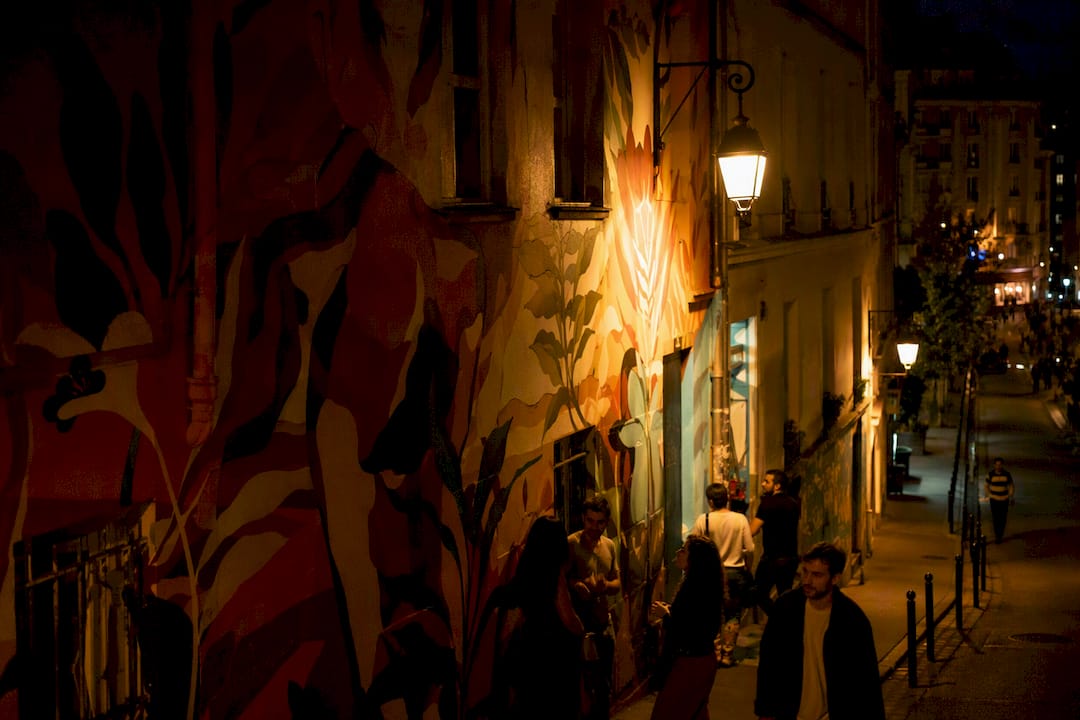 Rue de Belleville avec des graffitis et des lampadaires à lumière chaude