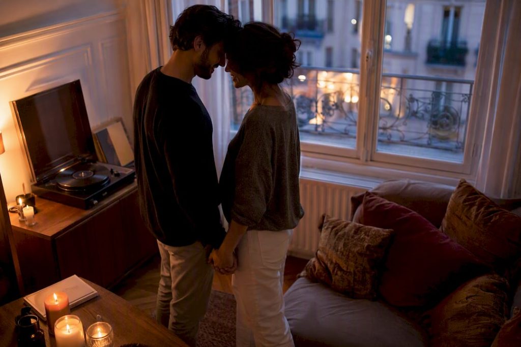 Mains de couple près d'une platine vinyle avec des bougies