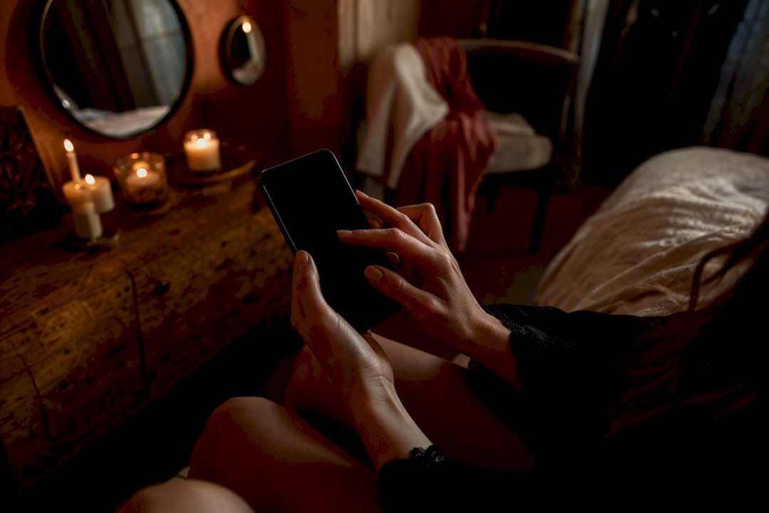 Mains réglant une playlist sensuelle sur un smartphone