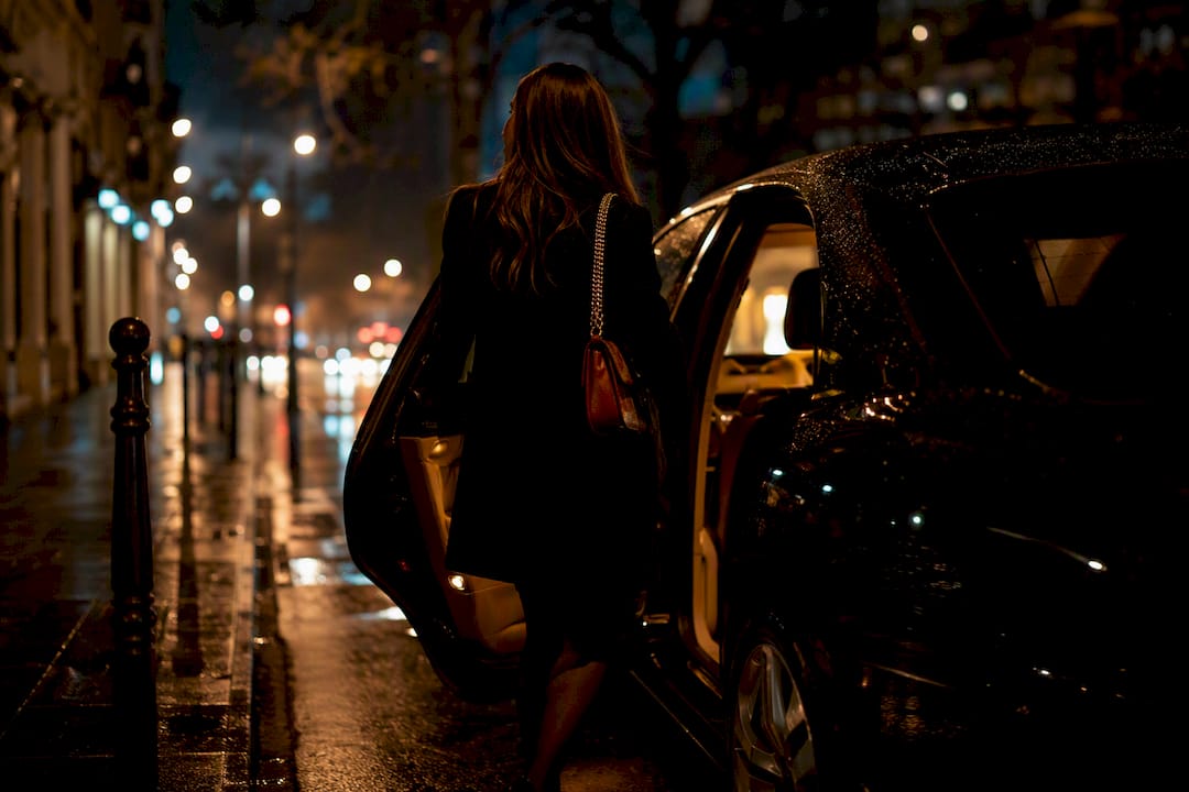 Une personne qui monte dans un véhicule de nuit