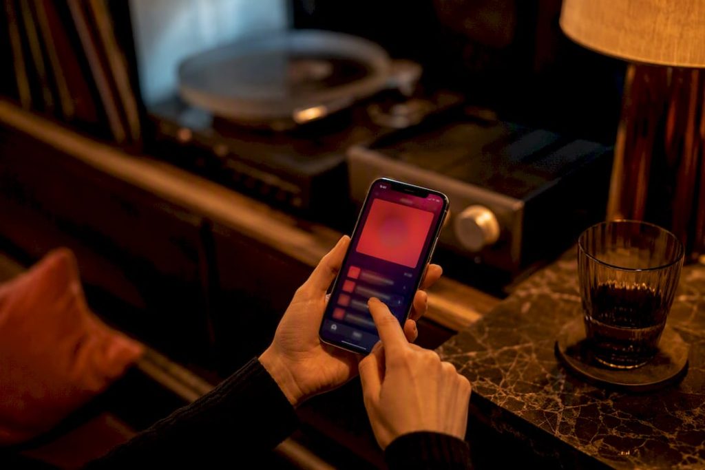 Une main choisissant une playlist dans une ambiance feutrée